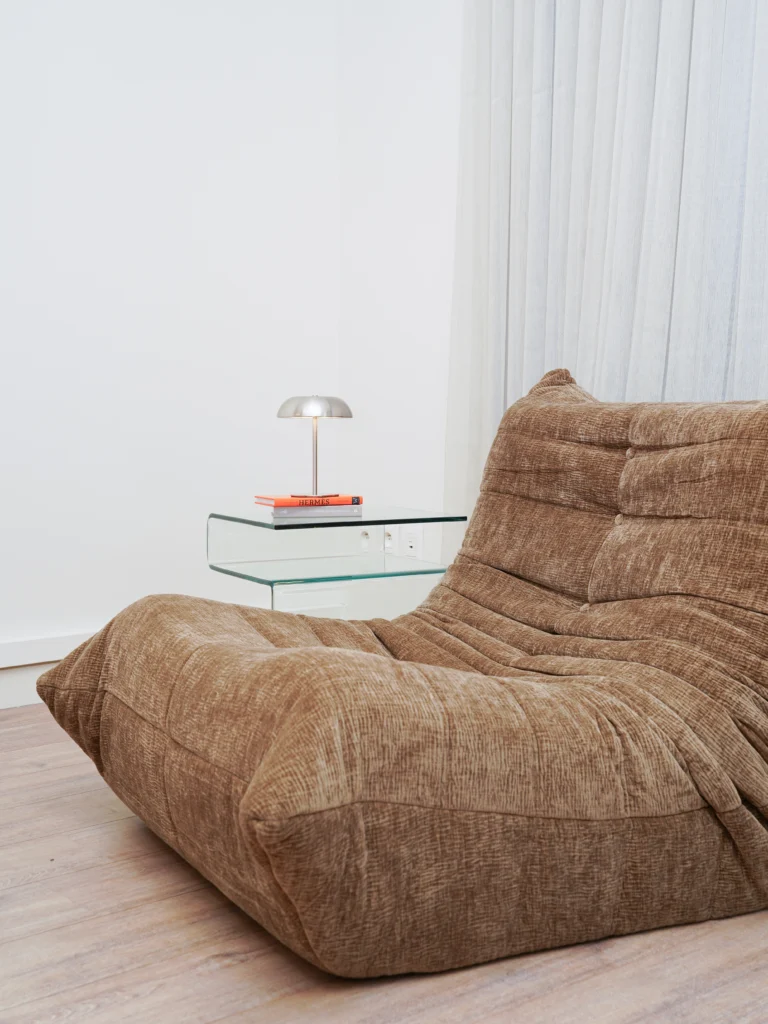 Modern brown lounge chair with glass side table and reading lamp in Antwerp studio