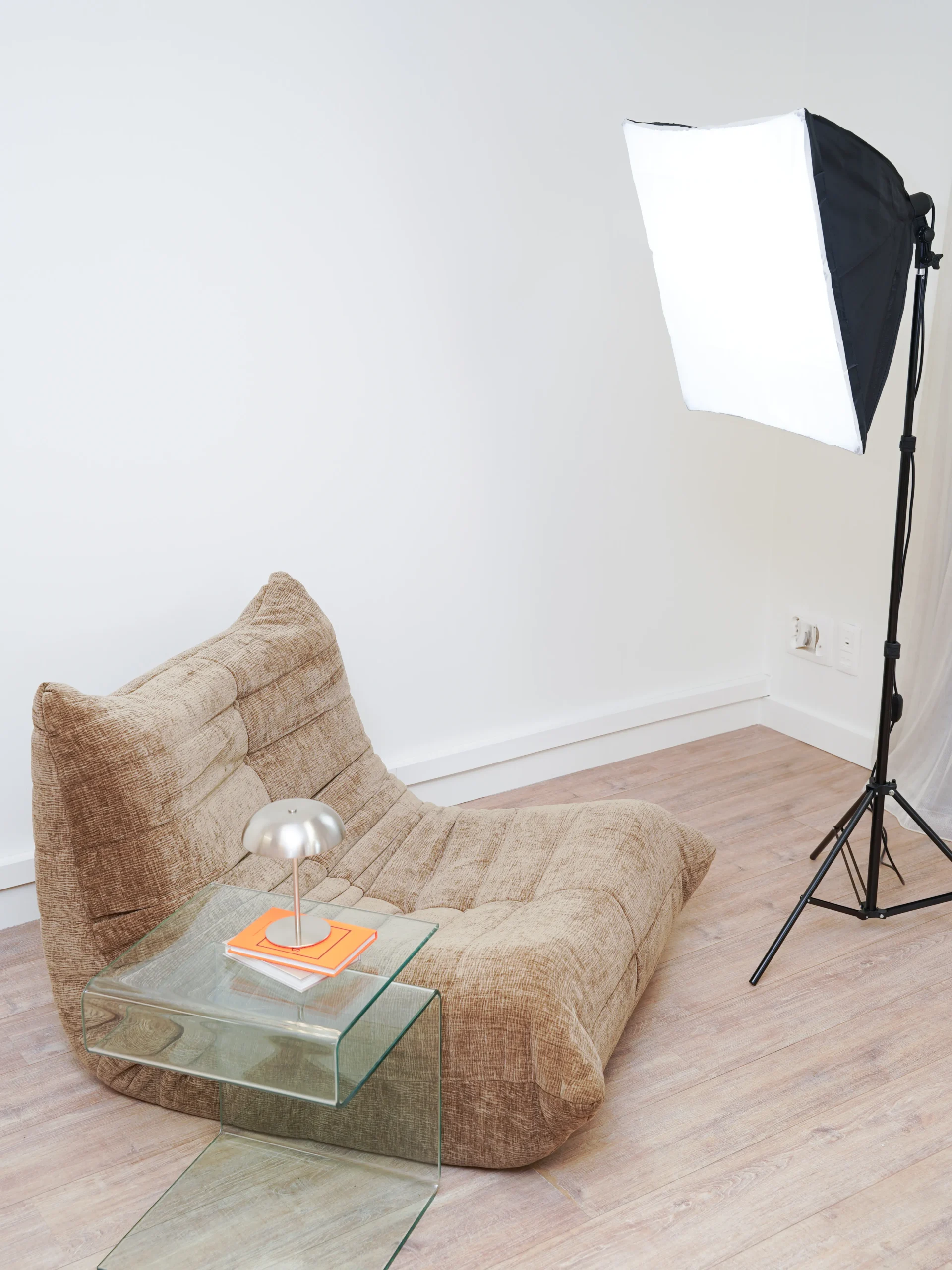 Brown lounge chair with glass table, lamp, and professional softbox lighting in Antwerp studio