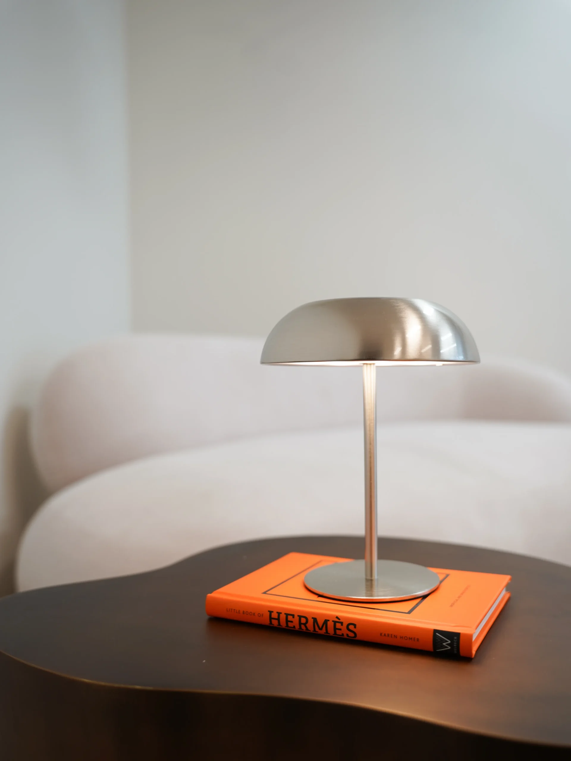 Close-up of modern silver lamp on orange Hermès book in Antwerp studio