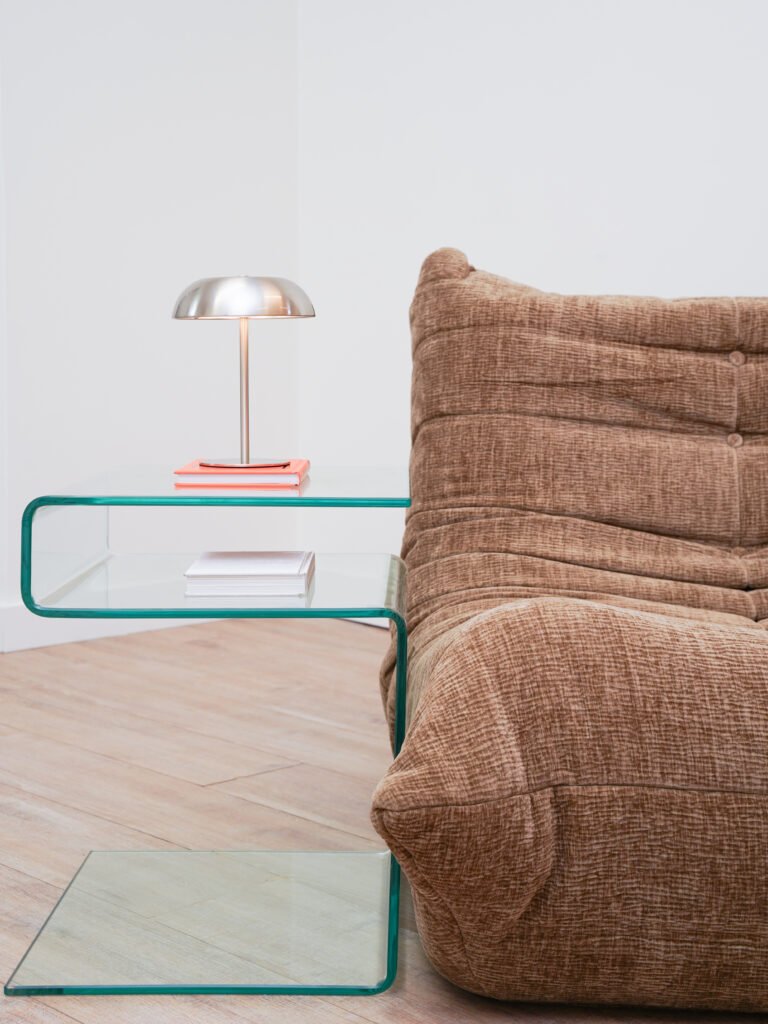 Close-up of brown lounge chair with glass table and silver lamp in Antwerp studio