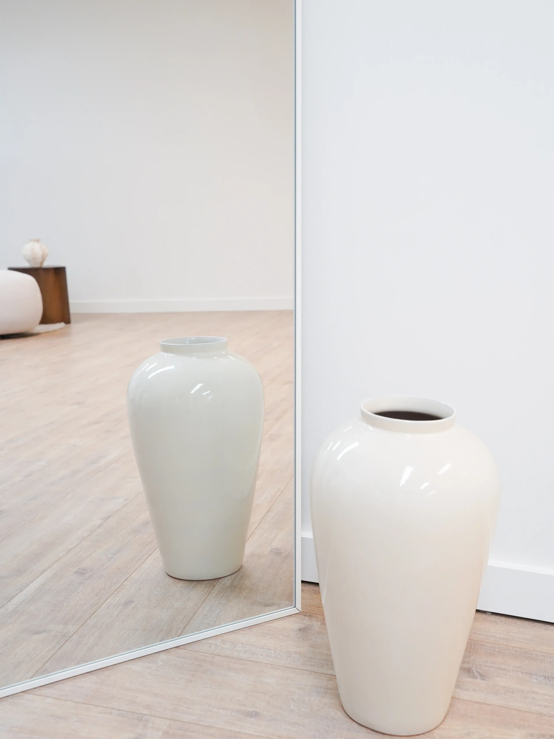 Large ceramic vase with mirror reflection on wooden floor in Antwerp content studio