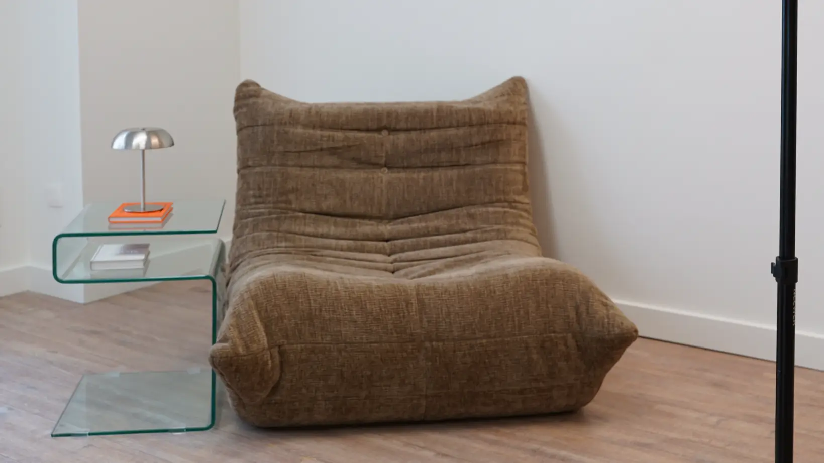 Brown lounge chair with glass table and silver lamp in Antwerp studio