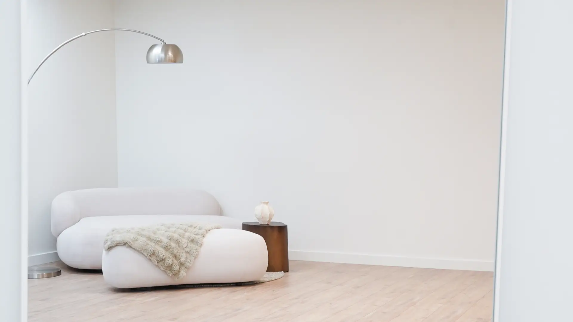 Wide view of studio lounge with modern sofa, blanket, and floor lamp in Antwerp